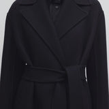 Front closeup view of black malika coat on model against a white background.