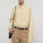 Front view of sand margan shirt on model wearing orange corduroys and brown belt, against a white background.