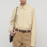 Front view of sand margan shirt on model wearing orange corduroys and brown belt, against a white background.