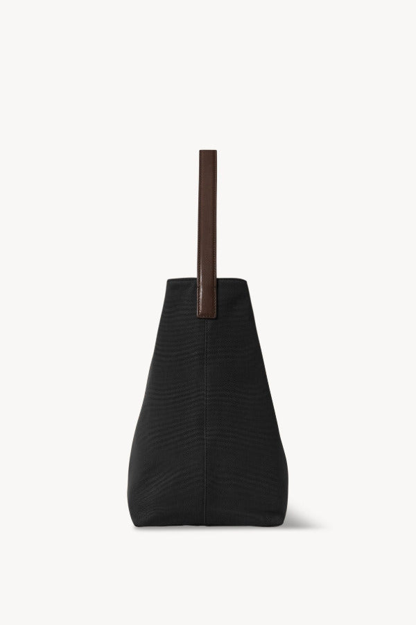 Side view of black medium n/s park tote on white background, with no model shown.