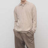 Front view of beige melange almot sweater on model wearing khaki pants, against a white background.