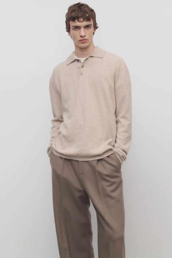 Front view of beige melange almot sweater on model wearing khaki pants, against a white background.