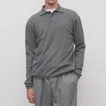 Front view of grey melange almot sweater on model wearing grey pants, against a white background.