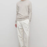 Front view of white belamy pant on model wearing beige top and sneakers, against a white background.