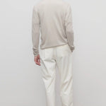 Back view of white belamy pant on model wearing beige top and sneakers, against a white background.