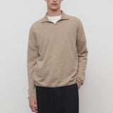 Front view of taupe men's franz sweater on model wearing black trousers, against a white background.