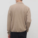 Back view of taupe men's franz sweater on model wearing black trousers, against a white background.