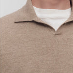 Front closeup view of taupe men's franz sweater on model wearing white undershirt, against a white background.