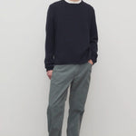 Front view of grey mens fred pant on model wearing black sweater and boots, against a white background.