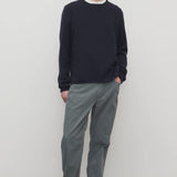 Front view of grey mens fred pant on model wearing black sweater and boots, against a white background.