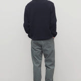 Back view of grey men's fred pants on model wearing black sweater and boots, against a white background.