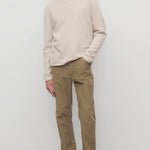 Front view of beige fred pant on model wearing oatmeal top and slides, against a white background.