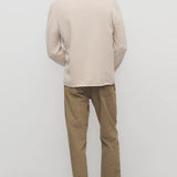 Back view of beige fred pant on model wearing oatmeal top and slides, against a white background.