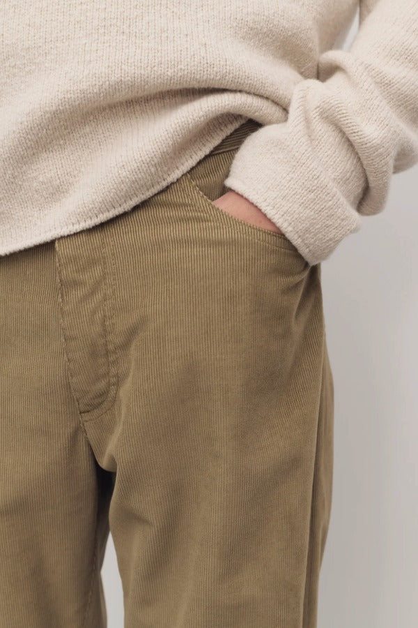 Front closeup view of beige fred pant on model wearing oatmeal top, against a white background.