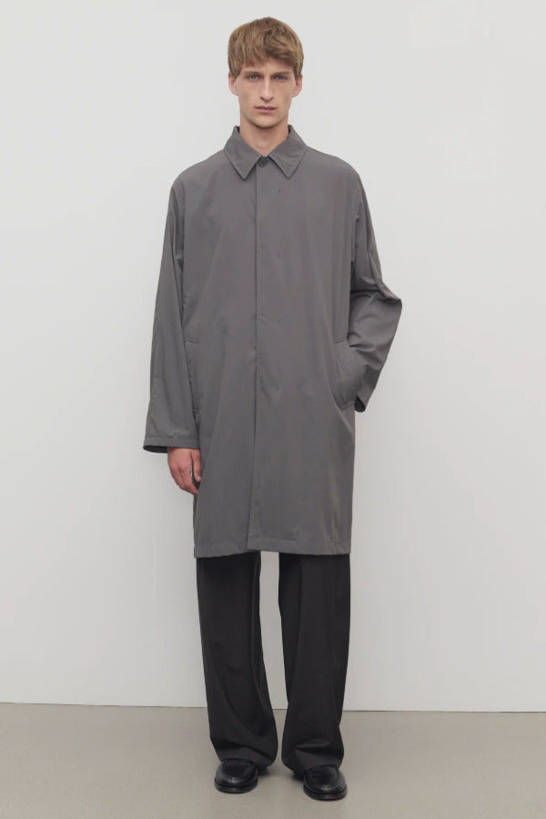 Front view of grey cobalt men's hesper coat on model wearing black pants and boots, against a white background.