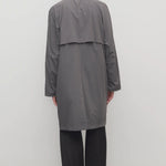 Back view of grey cobalt men's hesper coat on model wearing black pants and boots, against a white background.
