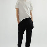 Front view of white luke t-shirt on model wearing black pants and loafers, against a white background.