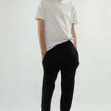 Front view of white luke t-shirt on model wearing black pants and loafers, against a white background.