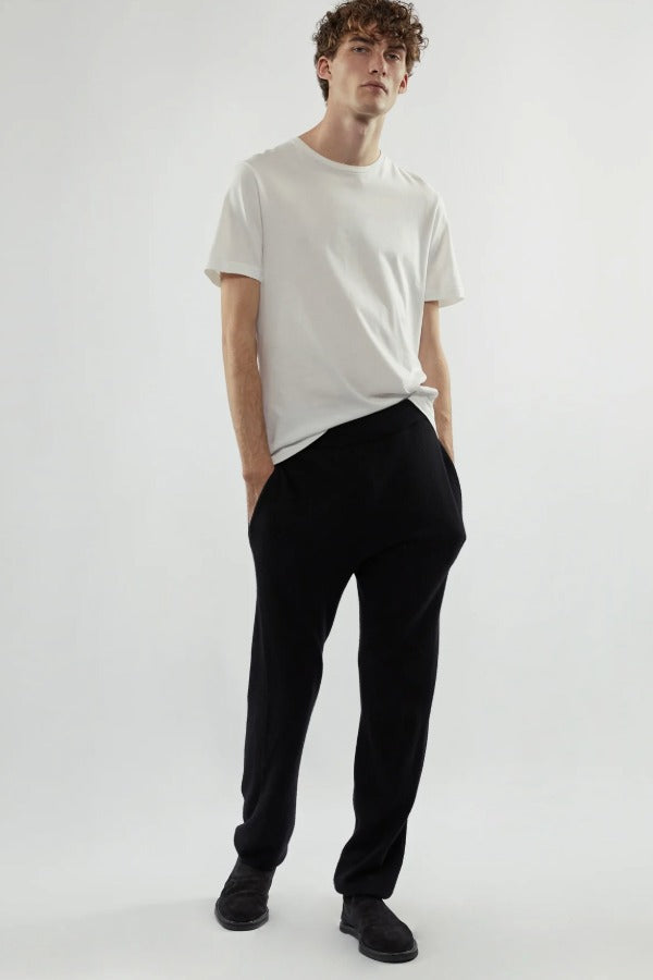 Front view of white luke t-shirt on model wearing black pants and loafers, against a white background.