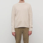 Front view of ecru nikola sweater on model wearing khakis, against a white background.