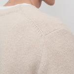 Back closeup view of ecru nikola sweater on model, against a white background.