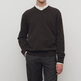 Front view of brown melange rod sweater on model wearing white shirt and grey trousers, against a white background.