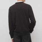 Back view of brown melange rod sweater on model wearing grey trousers, against a white background.