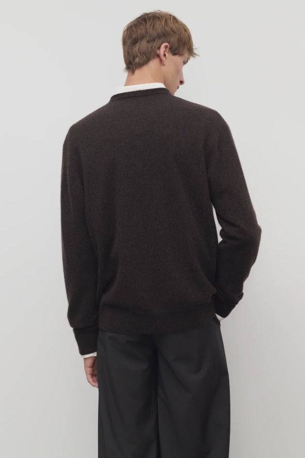 Back view of brown melange rod sweater on model wearing grey trousers, against a white background.