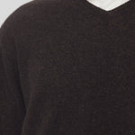 Front closeup of brown melange rod sweater on model wearing white shirt, against a white background.