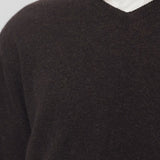Front closeup of brown melange rod sweater on model wearing white shirt, against a white background.