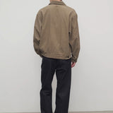 Back view of indigo rossen jean on model wearing khaki jacket and boots, against a white background.