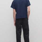 Back view of black sankuro pant on model wearing navy t-shirt and boots, against a white background.