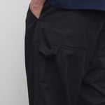 Back closeup view of black sankuro pant on model wearing navy t-shirt, against a white background.