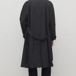 Back view of tarian coat on model wearing black pants and boots, against a white background.
