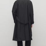 Back view of tarian coat on model wearing black pants and boots, against a white background.