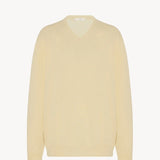 Front view of yellow migeia top on white background, with no model shown. 