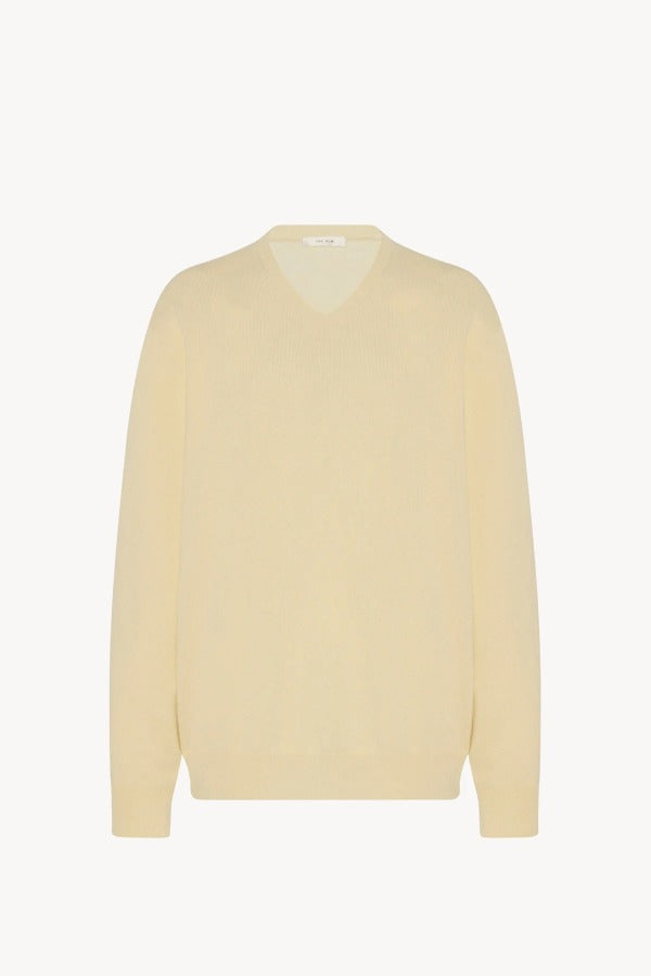 Front view of yellow migeia top on white background, with no model shown. 