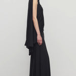 Side view of black mirla skirt on model wearing black top, against a white background.