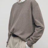 Side view of brown sepia misael top on model wearing khakis and a white top, against a white background.