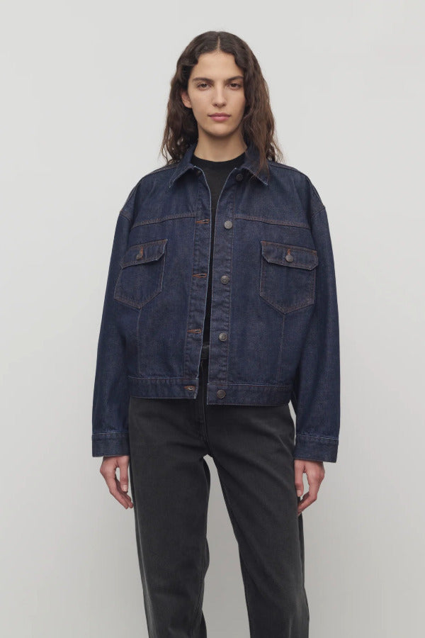 Front view of indigo ness jacket on model wearing black jeans and t-shirt, against a white background