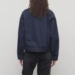 Back view of indigo ness jacket on model wearing black jeans, against a white background.