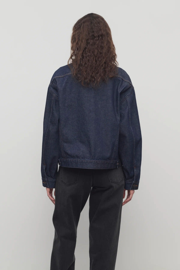 Back view of indigo ness jacket on model wearing black jeans, against a white background.