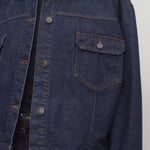 Front closeup view of indigo ness jacket on model wearing black jeans and t-shirt, against a white background.
