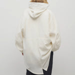 Back view of off-white Kemetina Coat on model wearing black trousers, against white background.
