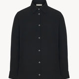 Front view of black petra shirt on white background, with no model shown.