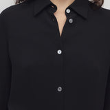 Front closeup view of black petra shirt on model, against a white background.