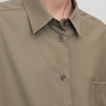 Front view closeup of military beige pino shirt on model, against a white background.