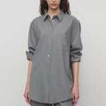 Front view of grey pino shirt on model wearing grey pants, against a white background.