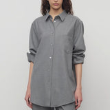 Front view of grey pino shirt on model wearing grey pants, against a white background.