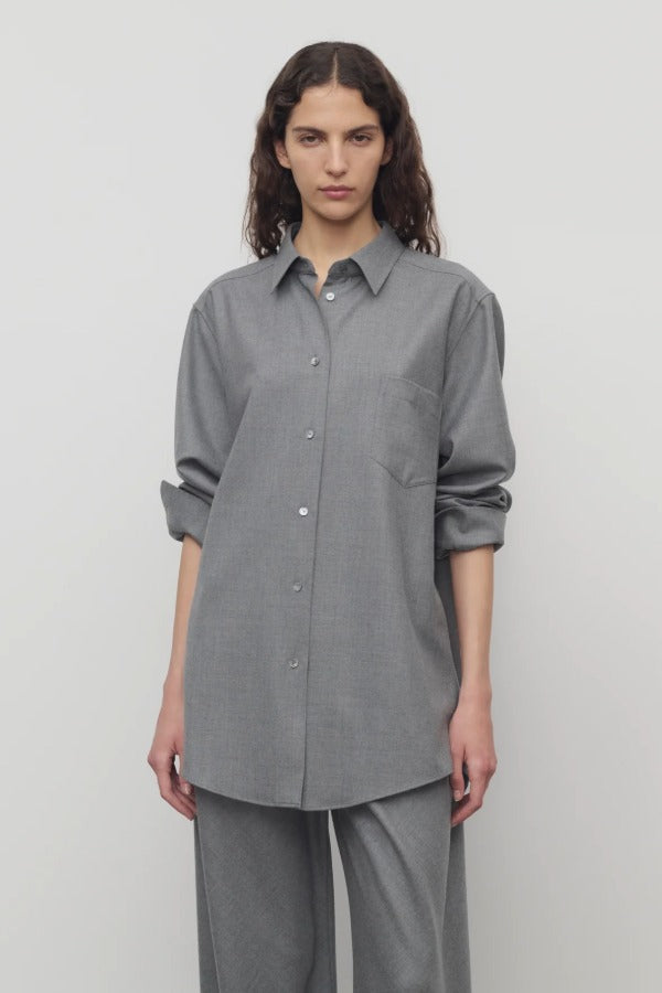 Front view of grey pino shirt on model wearing grey pants, against a white background.